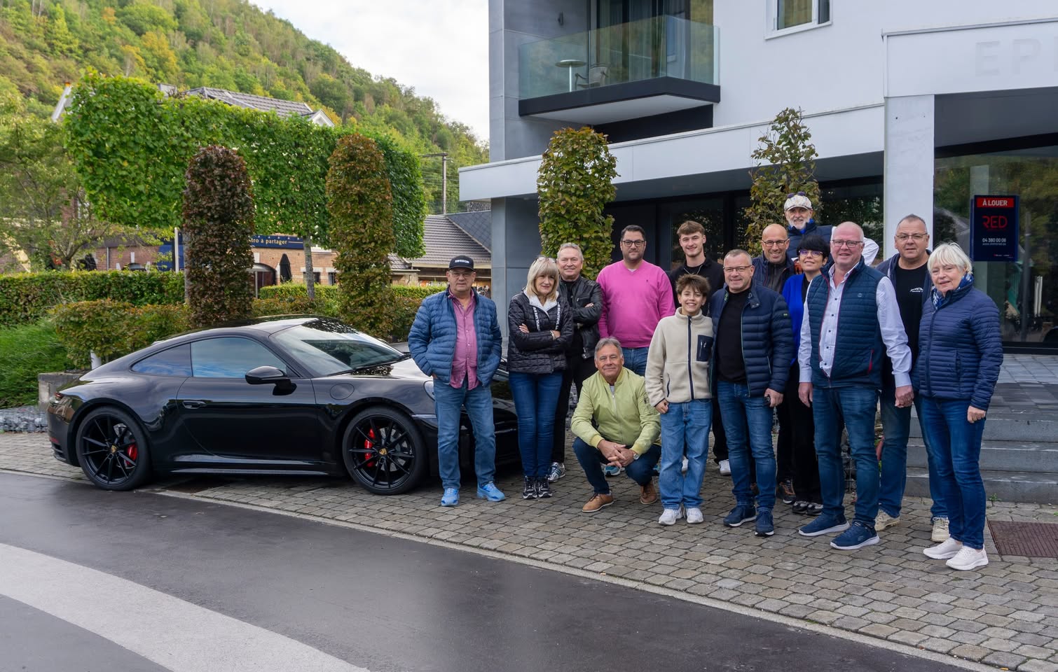 Photo de groupe devant une Porsche lors de la sortie du 11 octobre 2026